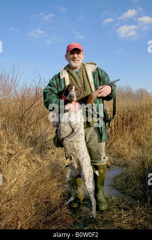 Pheasant hunter in upstate New York with Remington twenty gauge shotgun and German shorthaired pointer Stock Photo