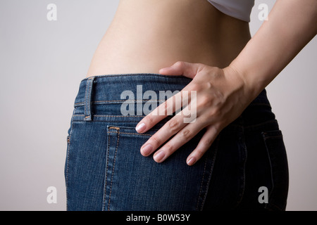 Woman standing with hand on hip, midsection Stock Photo