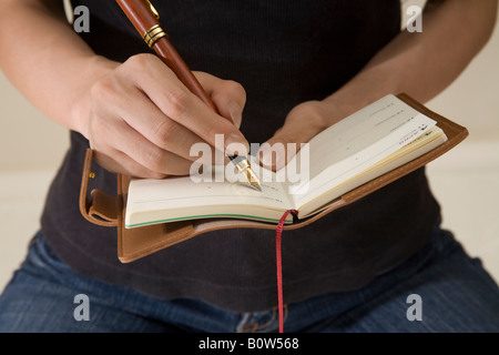 Man writing in diary, midsection Stock Photo