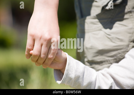 Mother and daughter holding hands outdoors, back view Stock Photo - Alamy