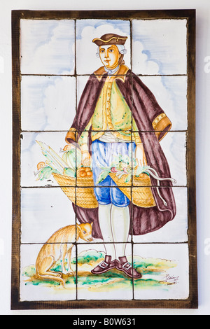 Ubeda Jaen Province Spain Azulejo in National Parador of man in 17th century costume carrying baskets of produce Stock Photo