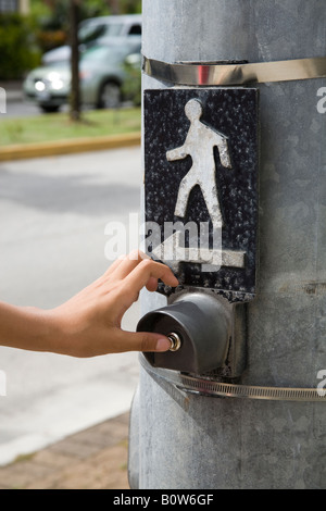 Man pressing button of pedestrian crossing sign Stock Photo