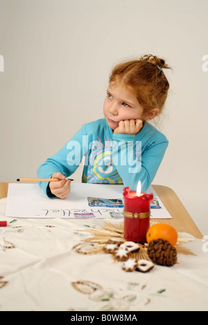 Little girl writing her Christmas wish list for Santa Claus Stock Photo