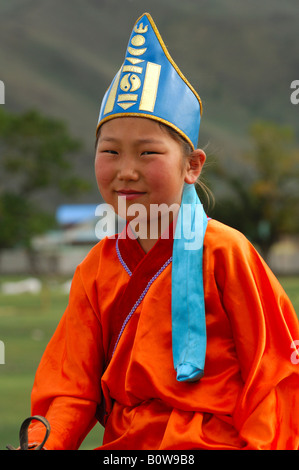 Ten-year-old girl wearing hat with soyombo emblem riding a horse, participant in the horsemanship competitions of the Naadam Fe Stock Photo