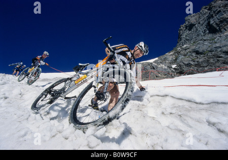 Mountain bikers in the snow, Transalp Challenge Mountain bike race, Pfunderer Joch Pass, Bolzano-Bozen, Italy, Europe Stock Photo