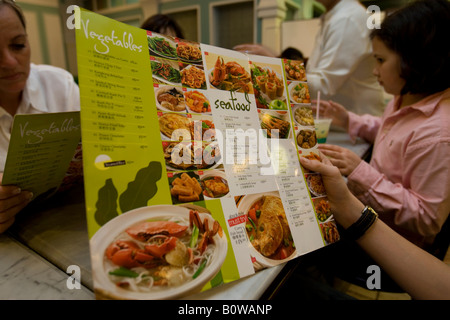Young man studying the menu in an Asian restaurant, Singapore, Southeast Asia Stock Photo
