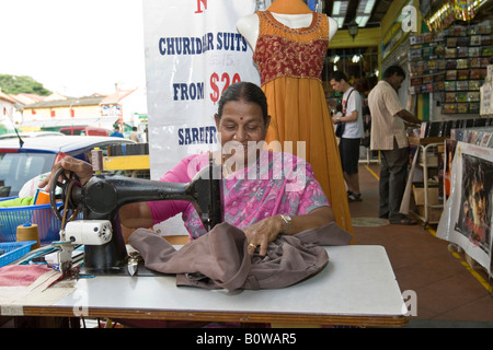 Old Indian woman sewing with an old sewing machine next to Kitchener Road in Little India, Indian Quarter, Singapore, Southeast Stock Photo