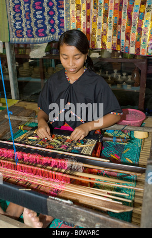 Woman weaving cloth in the traditional method on an old loom, Tete Batu, Lombok Island, Lesser Sunda Islands, Indonesia Stock Photo