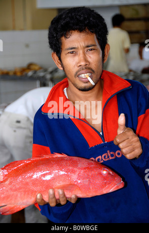 Man smoking a cigarette, fish vendor at the fish market in Sandakan, Sabah, Borneo, Malaysia, Southeast Asia Stock Photo