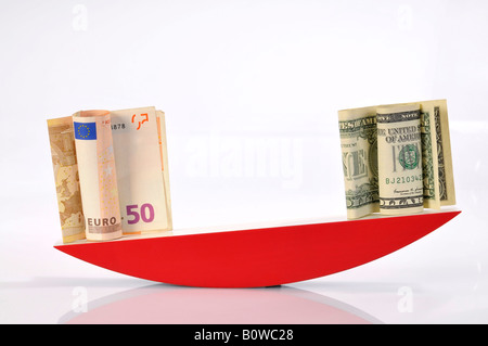 Euro banknotes and US Dollar bills on a scale Stock Photo