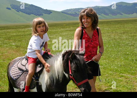 Mother next to daughter riding a pony, Umbria, Italy, Europe Stock Photo