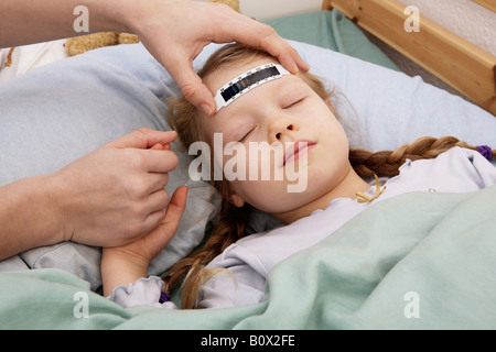 A young girl having her temperature taken with a forehead thermometer strip Stock Photo