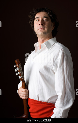 Stereotypical Spanish man in traditional clothing holding an acoustic guitar Stock Photo