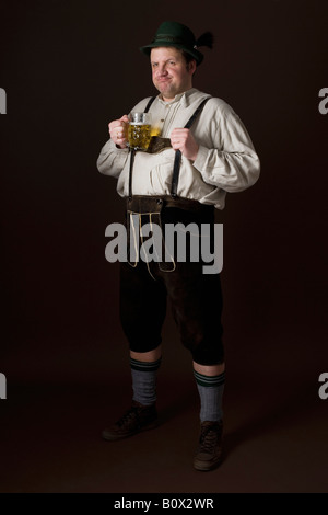 Stereotypical German man in Bavarian costume holding a beer Stock Photo