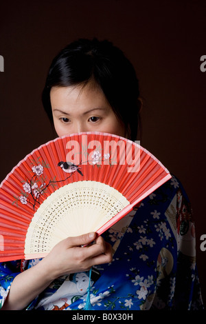 A woman in a kimono holding a folding fan Stock Photo