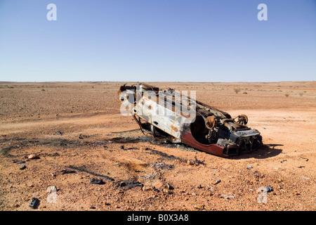 A burnt out car in a desert Stock Photo