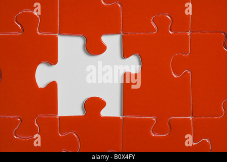 Missing piece in a red jigsaw puzzle Stock Photo