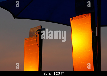 A tote board reflects the last rays of the sun at an evening race meeting at Towcester Racecourse Stock Photo