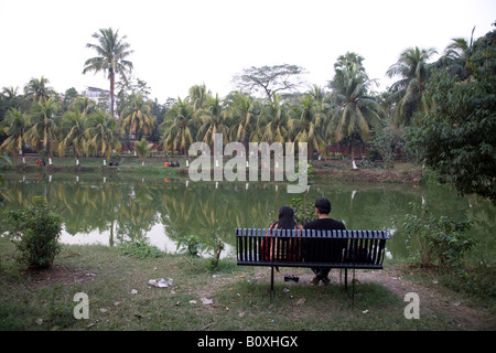 Romantic couple in park sitting on bench Stock Photo - Alamy