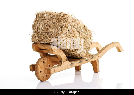 Wooden wheelbarrow and bale of straw Stock Photo