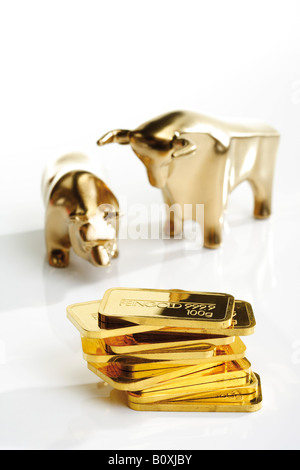 Bull and bear sculptures by gold bars Stock Photo