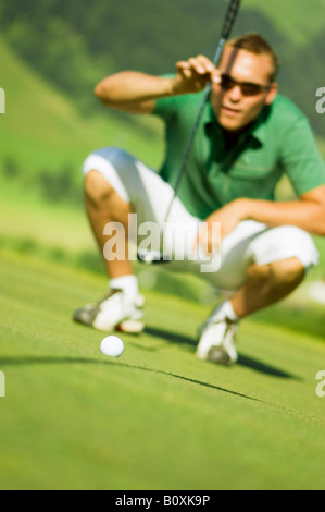 Golf player on the course, squatting Stock Photo