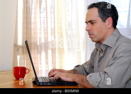 Man sitting at a desk and working on his computer Stock Photo