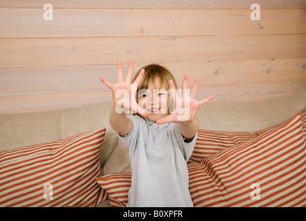 Boy (8-9) showing all ten fingers at camera, smiling, portrait Stock Photo
