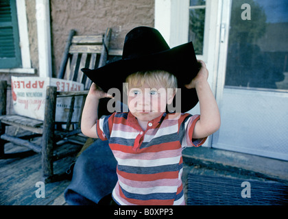 A young cowboy guest on the porch of the bunkhouse on a dude ranch near Lincoln New Mexico Stock Photo