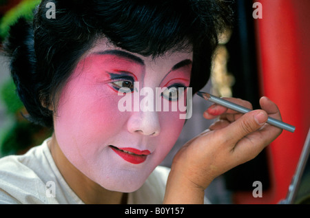 A Chinese dancer applies her makeup before a performance at the Magic Kingdom Stock Photo