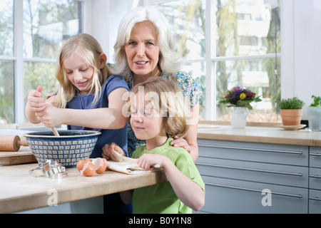 Grandmother and grandchildren (8-9) in the kitchen Stock Photo