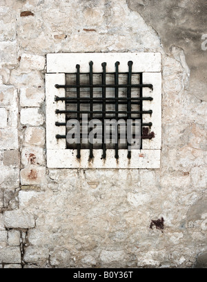 Bared or grilled window in an old wall Stock Photo