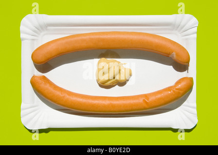 Two wieners with mustard on paper plate, elevated view Stock Photo