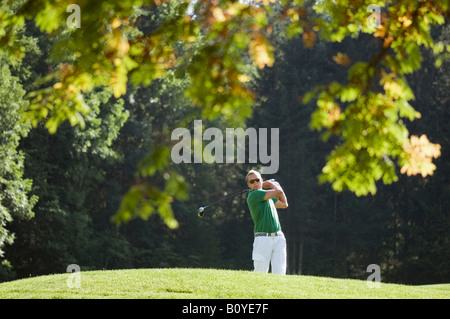 Golf player teeing off Stock Photo