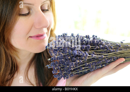 Mature woman smelling bunch of dried lavender Stock Photo