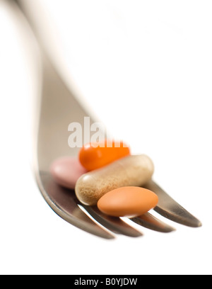 Pills on fork, close-up Stock Photo