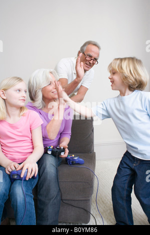 Grandparents and grandchildren (8-9) playing video game, portrait Stock Photo