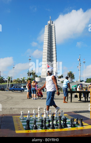 Men play dominoes in the Plaza de la Revolucion Havana IN the background is the Memorial Jos Marti, Cuba Stock Photo