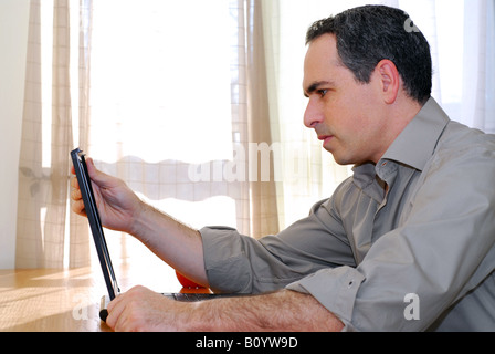 Man sitting at a desk and looking into his computer Stock Photo