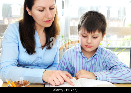 Teacher or tutor helping school boy to study Stock Photo