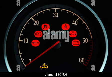 A BRITISH CAR DASHBOARD REV COUNTER DIAL WITH VARIOUS RED WARNING SYMBOLS LIGHTS SERVICING FUEL ENGINE SERVICE COSTS ETC,UK. Stock Photo