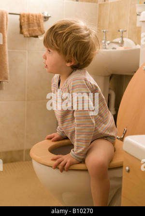young child, boy, learning to use the toilet, loo, sitting on seat, two years old Stock Photo