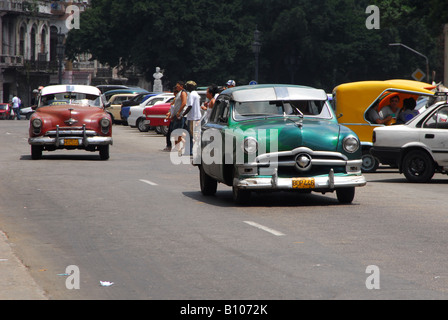 Classic American cars drive through the streets of Havana, where 50 year old cars are still in daily use Stock Photo