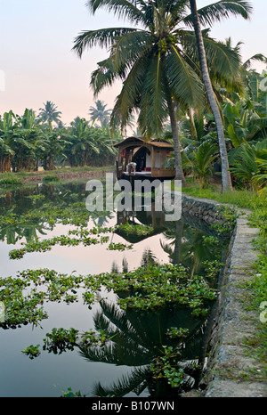 INDIA KERALA Renovated rice boat at sunset on canal in the backwaters of Kerala near Alleppey Stock Photo