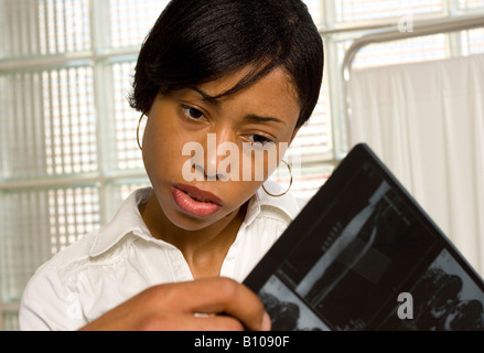 Nurse or female doctor examines x-ray in the medical office or hospital. Stock Photo