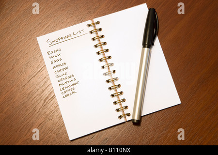 A shopping list and pen on a table top Stock Photo