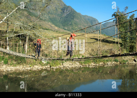Woman Crossing Rope Two Red Dzao women crossing rope bridge Cat Cat Valley near Sapa ...
