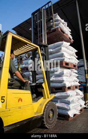 Forklift truck laden with genaeral cargo goods in acks stacking in yard at Port Khalid United Arab Emirates Middle East Stock Photo