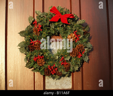 Christmas Wreath hanging on wooden door Stock Photo