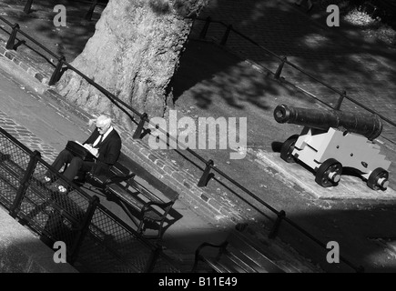 An old man sitting by himself in front of a canon Street Photography outside Tower Hill tube station, Central London Stock Photo